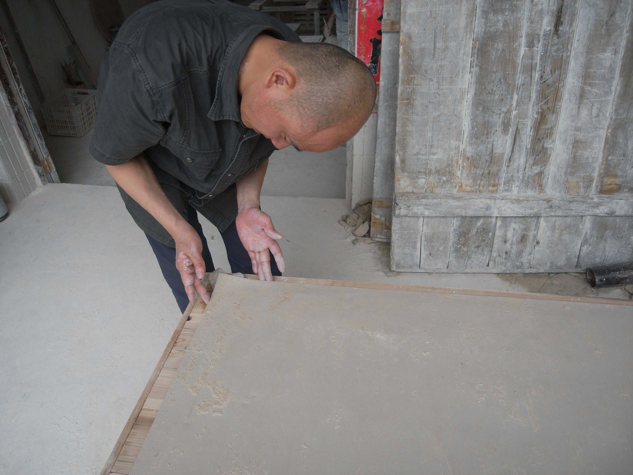 Liu Jianhua molding clay to create the slightly upturned corner of Blank Paper (2009). Photo courtesy of the artist