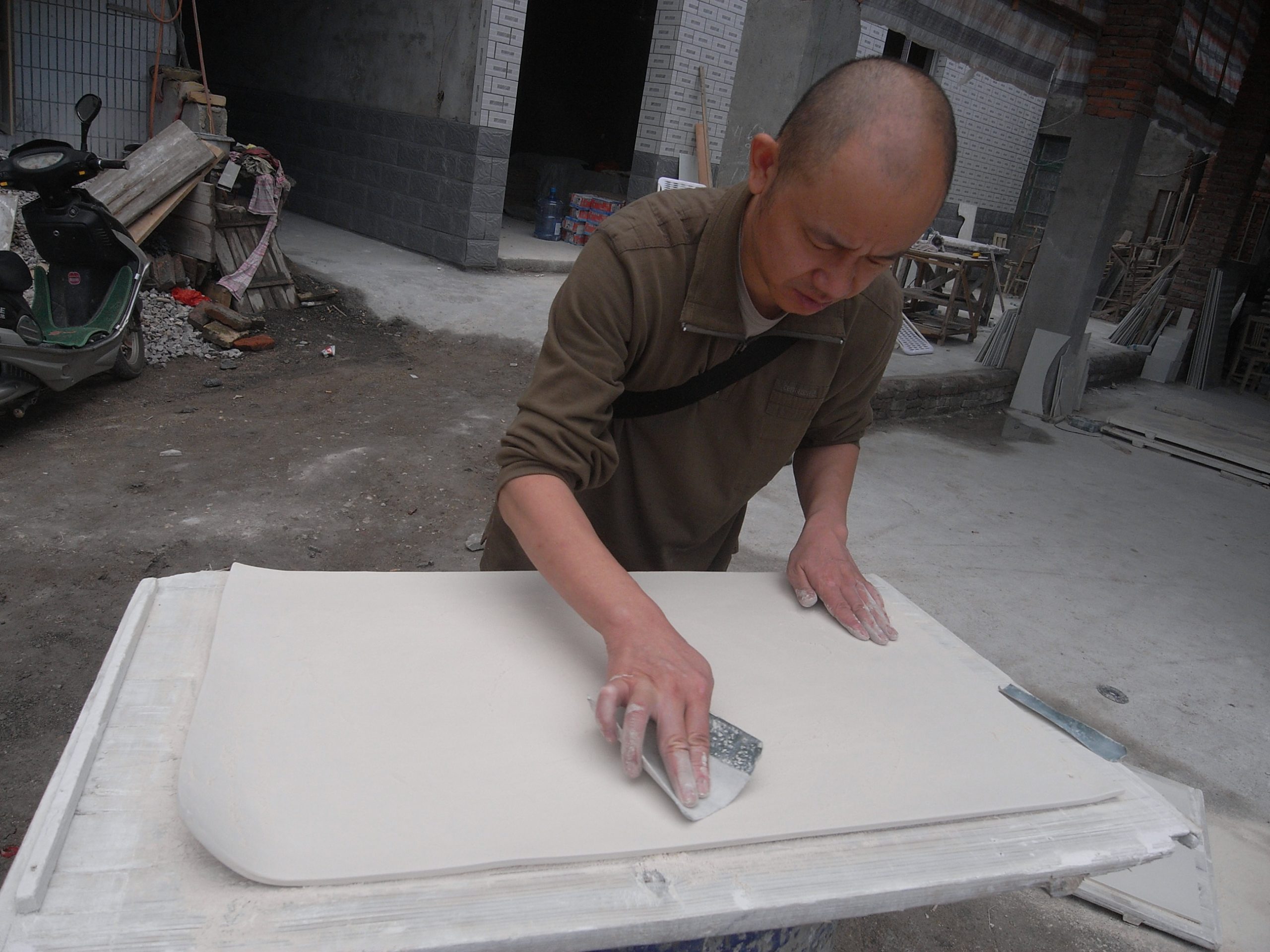 Liu Jianhua smoothing out the clay surface of a work. Photo courtesy of the artist.