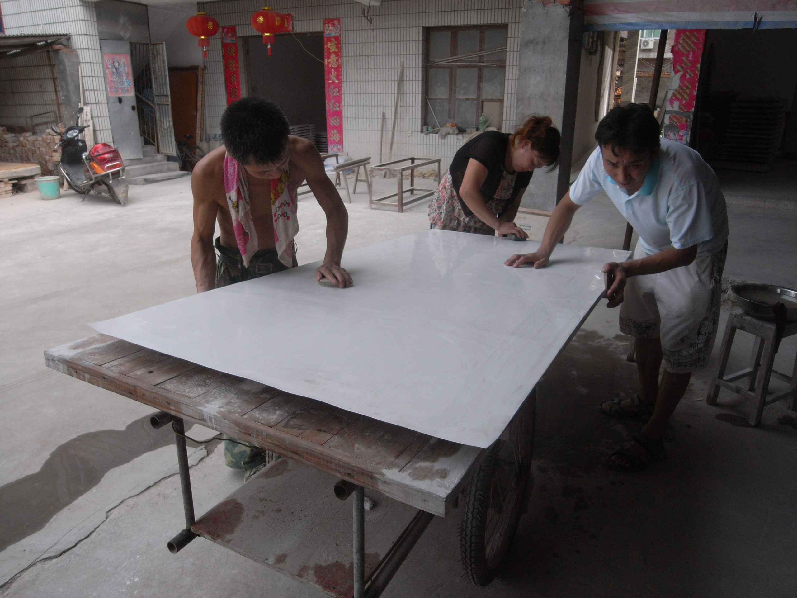 Studio assistants polishing the surface of a work. Photo courtesy of the artist.