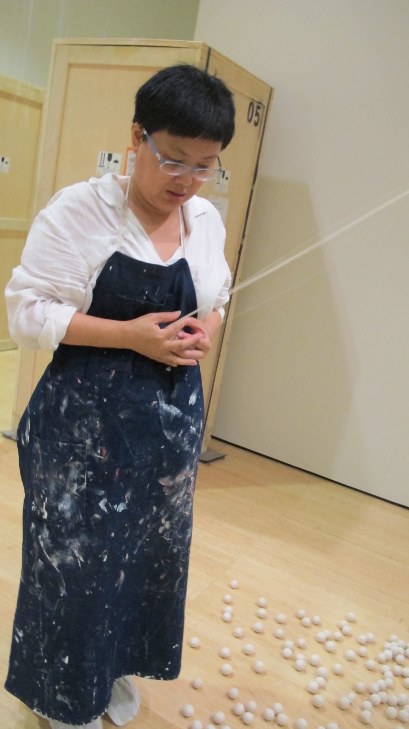 Lin Tianmiao unwinding thread for a work in Bound Unbound: Lin Tianmiao, Asia Society Museum, 2012-2013. Photo courtesy of the artist.