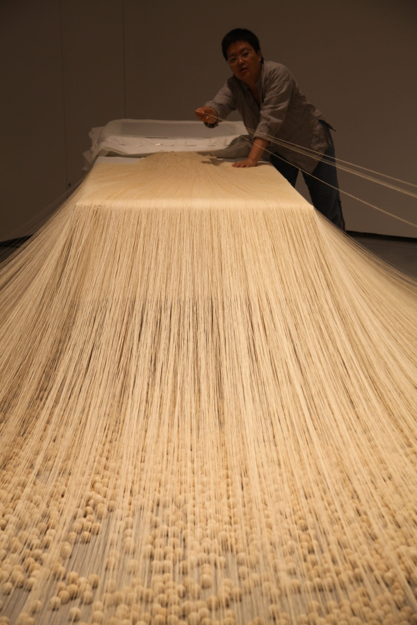 Lin Tianmiao installing The Proliferation of Thread Winding (1995) for the exhibition The Civil Power, Minsheng Art Museum, 2015. Photo courtesy of the artist.