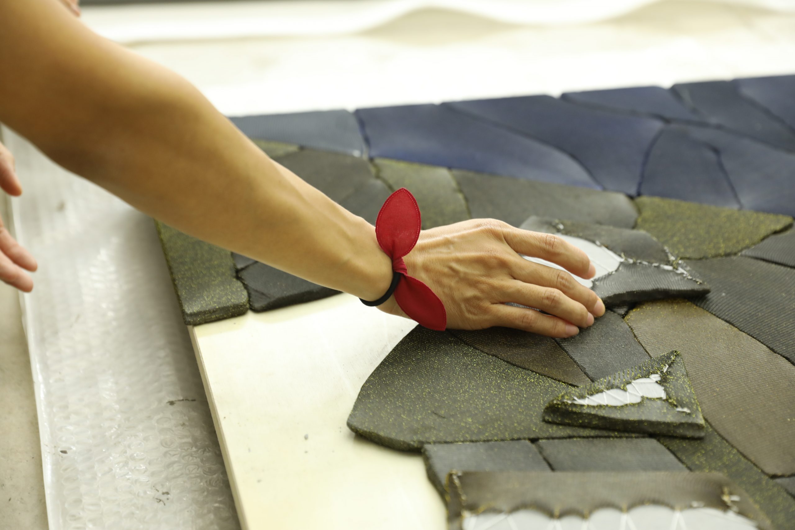 Ma Qiusha revealing the sewn backsides of two wrapped concrete shards in a work in her studio. Photo commissioned by the Smart Museum of Art during an artist interview. Photo by Yaya Rotem.