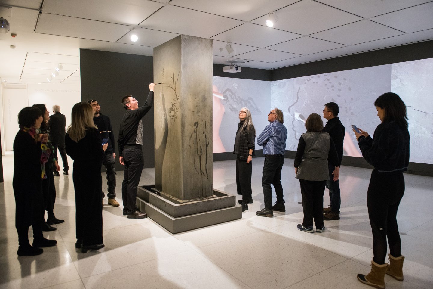 Visitors to the Smart Museum use water and brushes to write on Song Dong's Traceless Stele.